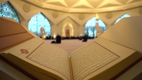 A Man Is Reading Quran Or Koran On The Reading Desk In A Mosque.