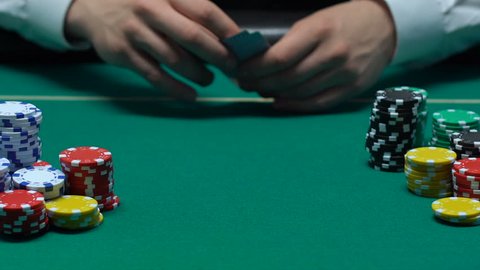 Player hand throwing pair of aces on table, win combination, poker bet, success