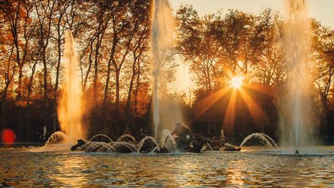 Beautiful sunset at Apollo Fountain in Versailles Gardens.  France/The basin of Apollo at Versailles palace gardens. France. A bronze sculpture group in the middle of the fountain. 
