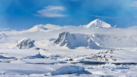 Antarctica Nature. Snow-capped mountain range against blue cloudy sky. Magestic snow winter landscape. Exploring beauty world, holidays, recreation, travel concept. 4K Slow Motion Parallax Effect