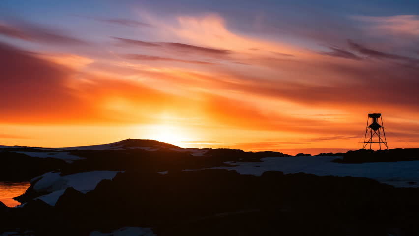 Antarctica Nature. Beautiful cloudy dramatic sky with sun rising up. Colorful orange sunset. Clouds in sky flow. Majestic winter landscape. Travel background. 4K Slow Motion Time Lapse Parallax