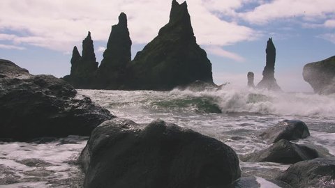 Waves on the ocean covers camera with water, Icelandic landscape, slow motion