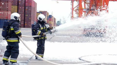 anonymous firefighters using fire-extinguishing foam