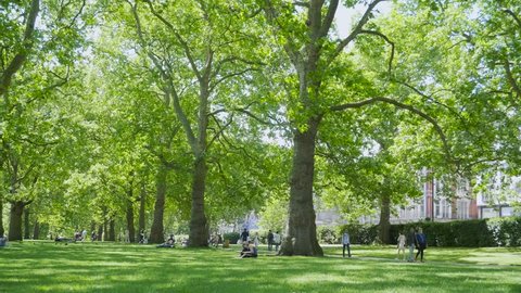 LONDON, UK - May 22, 2017: People enjoying the peaceful Green Park in London on a sunny day.