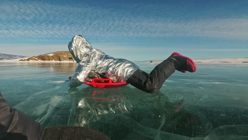 Man is turning a woman on ice. Father turns his daughter and her mother on an ice. Family has fun and sports time in nature. Rotate people. Slow motion.