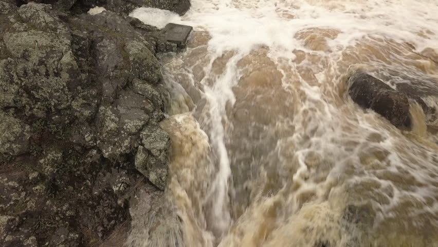 Closer look while going up the waterfalls the brownish color water and the big black rocks