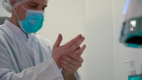 Medical worker disinfect hands with anticeptic gel