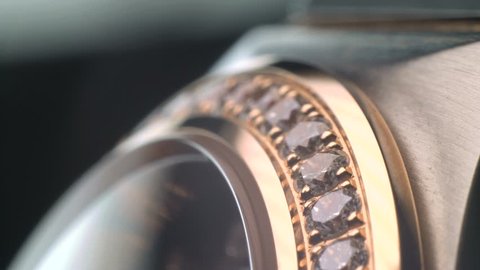 Luxury expensive fashion gold watches with sapphires and diamons.Arrows ticking. Close up 4k macro shot.