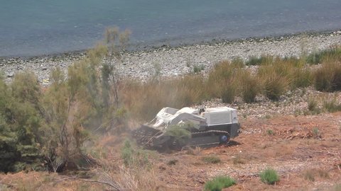 Engineers of 4M defense use remote controlled prime mover for mine clearance and ground preparation to clear mines from old Syrian minefield on Gofra beach in the sea of Galilee, Israel, July 19, 2018