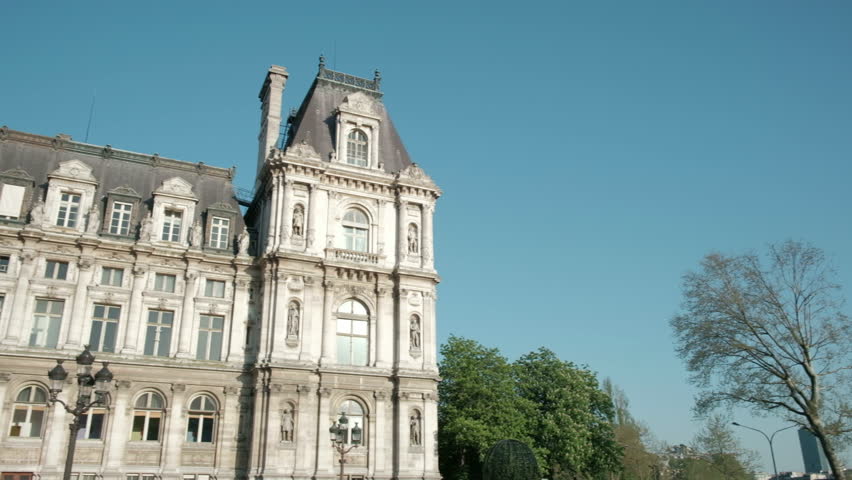 Camera pan left view of angled front facade of Hotel De Ville city hall in Paris, France