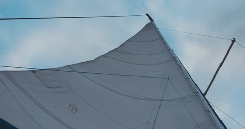 View of mainsail of yacht sailing on a large lake. 4K UHD 60 FPS SLO MO
