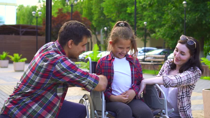Family with a disabled child in a wheelchair, happy | Shutterstock HD Video #1014190100