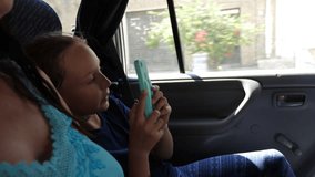 Teenager girl shooting video by mobile phone while travel in car