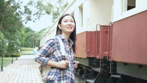4K footage. happy Asian tourist woman at railway station, walk to the train and step up on stair. travel in Asia by vintage train. leisure tourist travelling by train transportation, retro color