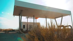 Old dirty deserted gas station. U.S. Route 66. crisis road 66 fueling slow motion video. closed supermarket store shop Abandoned gas station oil end of fuel the world apocalypse petrol. main street of