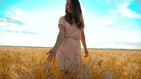 girl is walking along the wheat field nature slow motion video. Beautiful girl in white dress running nature freedom happiness hands to the side on lifestyle field at sunset light and the blue sky