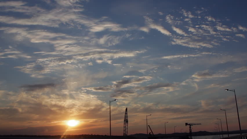 Drive through the Brige under construction with dramatic Clouds and the setting Sun. Sunset