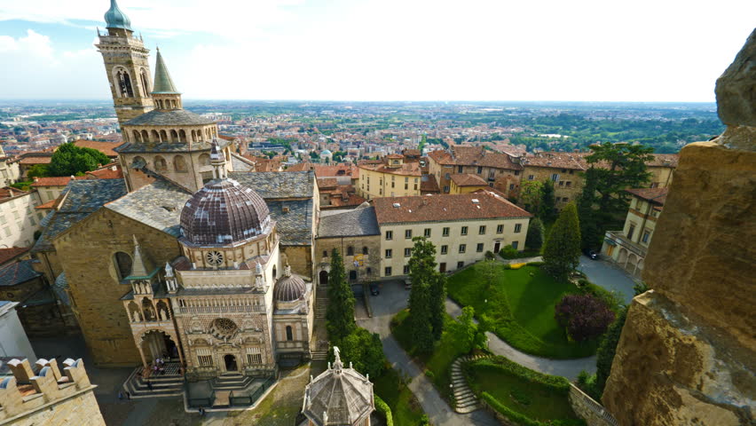 Aerial view of the Basilica of Santa Maria Maggiore and Cappella Colleoni in Citta Alta of Bergamo, Italy on a sunny day | Shutterstock HD Video #1014197516
