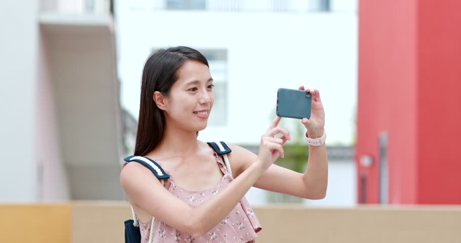Woman taking photo on cellphone in Shenzhen