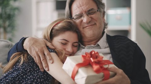 Young daughter gives her father a gift