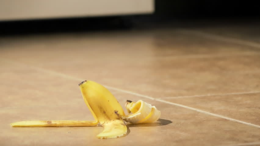 Slipping on banana peel and falling down closeup  Royalty-Free Stock Footage #1014213683