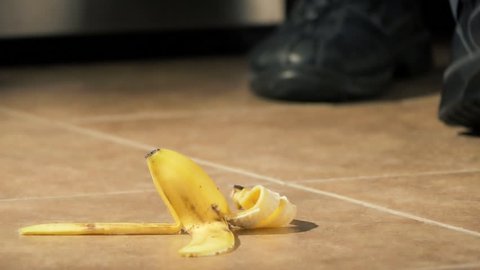 Slipping on banana peel and falling down closeup 