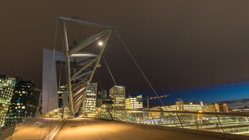 Oslo Norway time lapse 4K, city skyline day to night timelapse at Akrobaten pedestrian bridge and Barcode Project