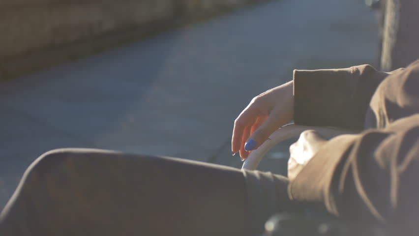 Nervous woman siitng on a bench and impatiently waiting for someone.