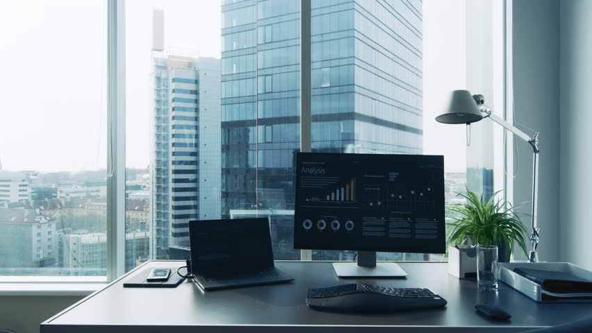 Following Shot of the Confident Businessman in a Suit Walking Through His Office and Looking out of the Window Thoughtfully. Stylish Modern Business Office with Personal Computer and Big City View. Royalty-Free Stock Footage #1014231674