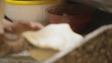 pizzaiolo is preparing the focaccia with Neapolitan oil and oregano in a wood-burning oven
