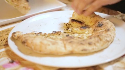 pizzaiolo is preparing the focaccia with Neapolitan oil and oregano in a wood-burning oven

