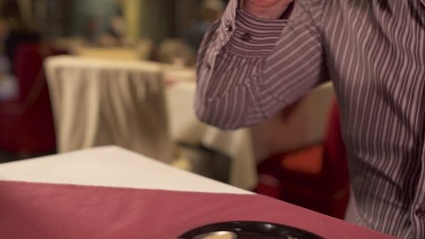 Man takes woman's hand at date in restaurant