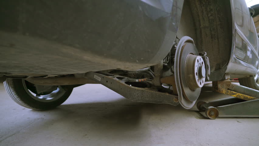 The rusty screws on the floor scattered inside the auto shop where cars are being repaired