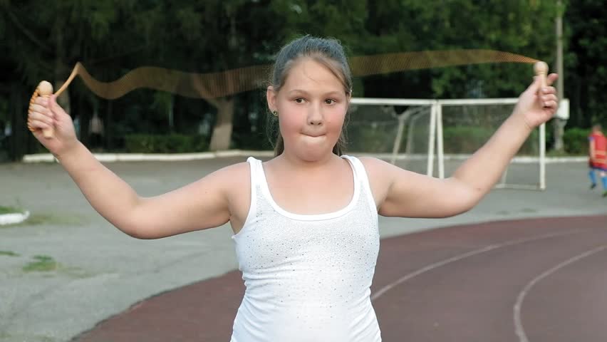 Little girl jumping rope in the stadium