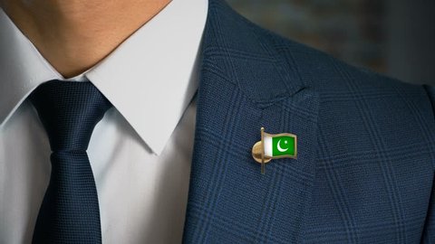 Businessman Walking Towards Camera With Country Flag Pin - Pakistan