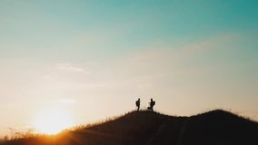 two men tourists hikers silhouette go to the mountains sunset travel slow motion video. Traveler successful young men walking on top lifestyle of Mountain and waiting for sunrise. travel tourists in