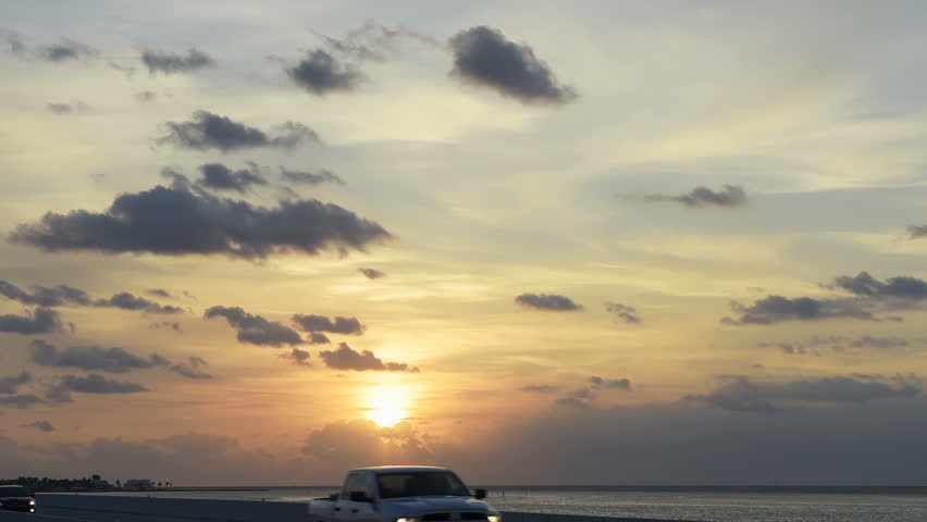 Sunrise in Florida Keys, Islamorada village of islands, with pink blue sky, overseas highway road, in Atlantic Ocean, gulf of Mexico, horizon, cars in slow motion