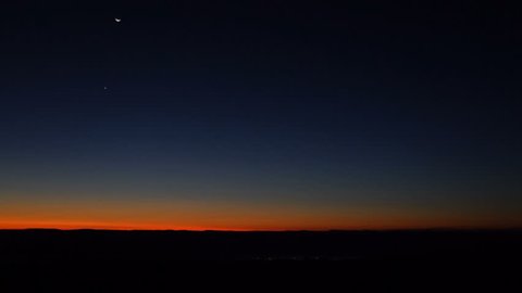 Morning dark sunrise with blue sky and flickering city lights in Dolly Sods, Bear Rocks, West Virginia with overlook of mountain valley, stars, moon, and Jupiter, Venus, Mars planets