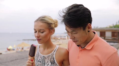 Young couple walking and eating ice cream together