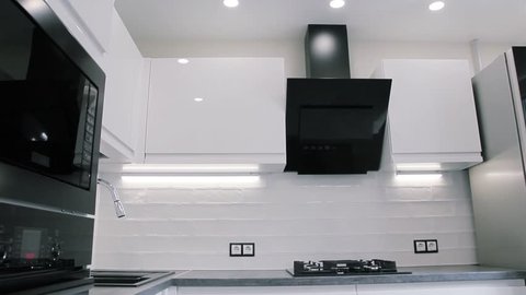 interior of white modern compact kitchen. suspended ceiling with LED lamps.