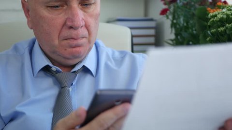 Businessman Using a Cellphone Verify Contracts and Invoices