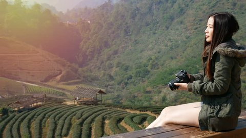 4K footage of happy Asian tourist woman taking photo of beautiful nature from tea field plantation in Asia by digital camera at sunrise time. travel and vacation concept 스톡 비디오