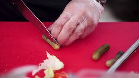 knife cutting pickles on wooden board. Clip. Cook cuts pickled cucumbers, knife in female hands, cooking process, beautiful little cucumbers, close-up, chef cuts cucumbers