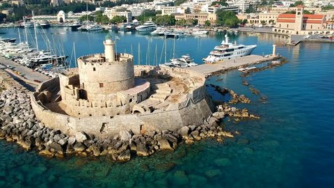 Aerial birds eye view drone video of Rhodes city island, Dodecanese, Greece. Panorama with Mandraki port, lagoon and clear blue water. Famous tourist destination in South Europe
