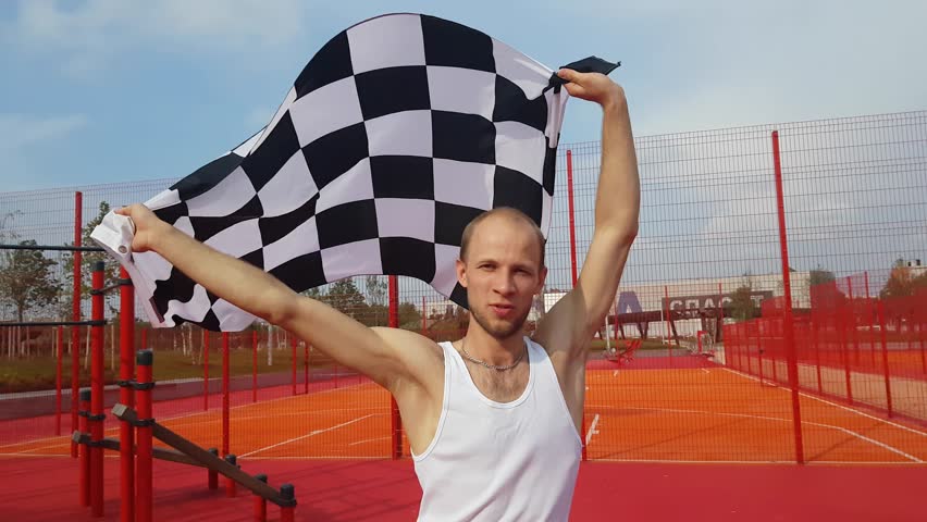Yang man with finish checkered flag outdoors