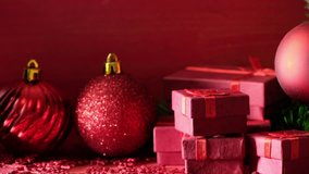 Red Christmas background theme with decorations and gift boxes on wooden board. Establishing b roll shot.