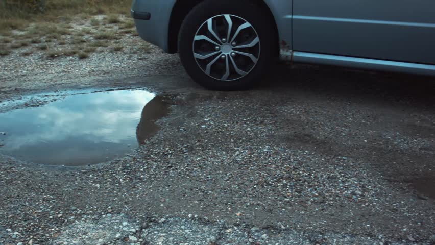 Some feet jumping into a puddle of dirty rainwater