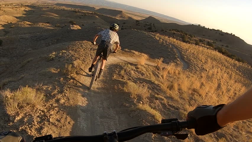 Thrilling POV, point-of-view of a mountain biker following another one on Joe