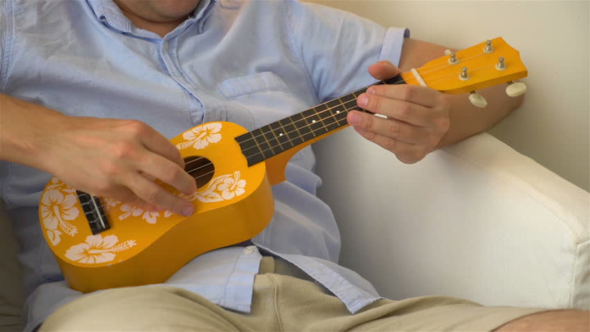 Professional video of young man playing ukulele