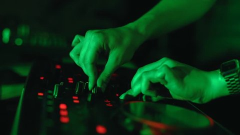 Close-Up of the Hands of Young Female DeeJay Controls DJ Mixer the Party